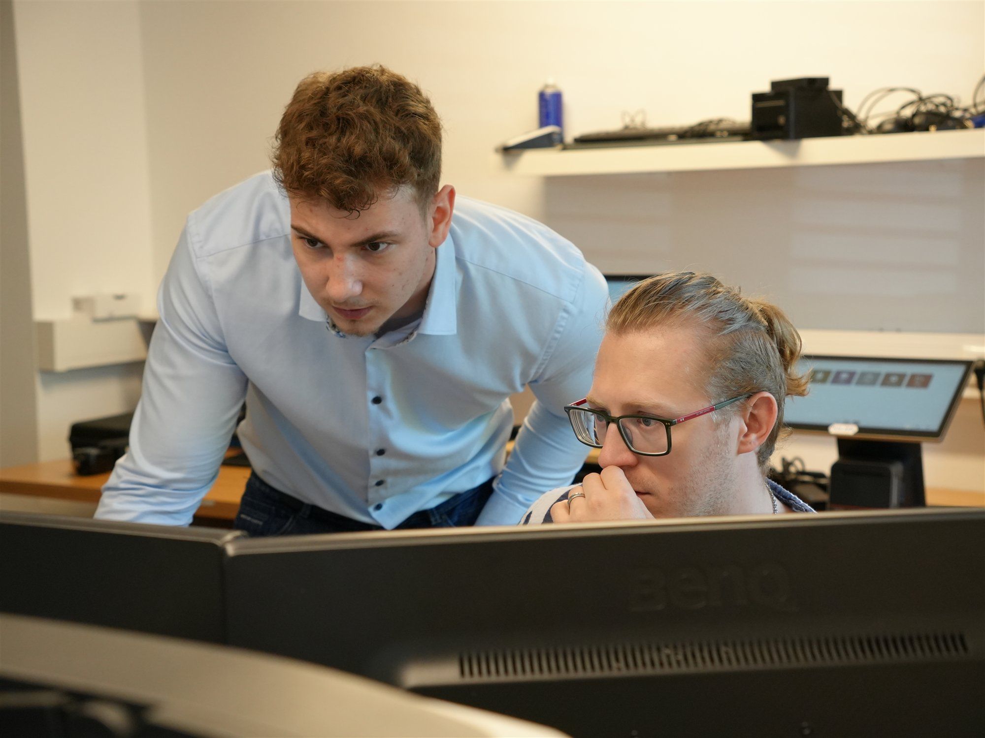 Zwei Holzer-Mitarbeiter lösen gemeinsam ein Problem am Computer