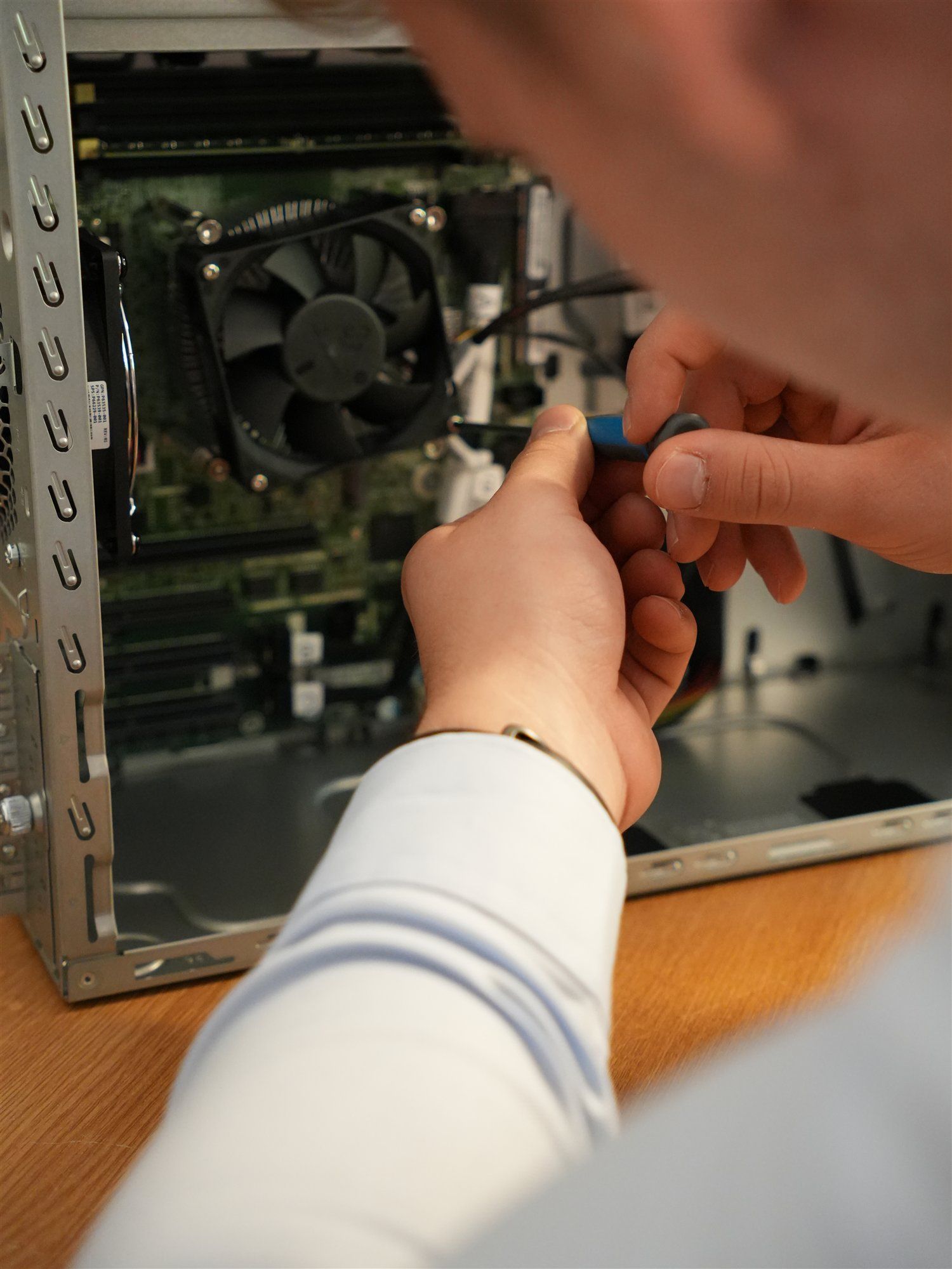 Holzer-Techniker arbeitet mit einem Schraubendreher in einem geöffneten PC-Gehäuse